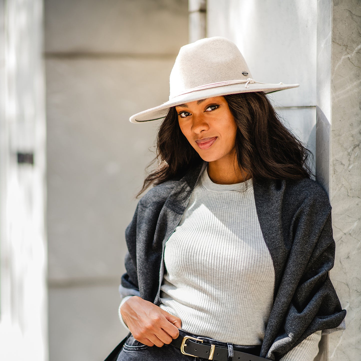 Woman posing on a city street in the Wallaroo Women’s Colorado Felt Wide Brim Sun Hat, showcasing a bold, timeless style with UPF 50+ sun protection for sunny urban outings, Oatmeal