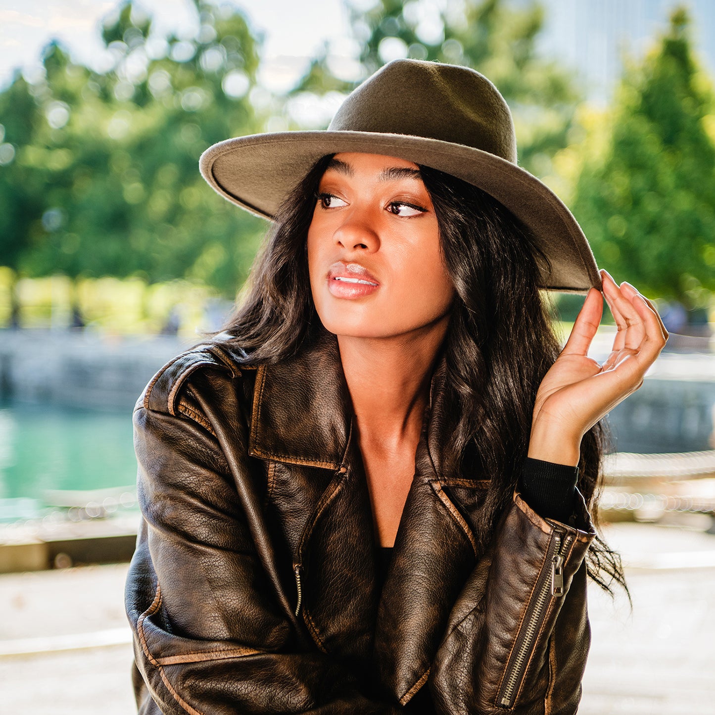 Woman attending an outdoor winter festival in the Wallaroo Colorado Felt Fedora, offering a fashionable wide brim, UPF 50+ sun protection, and a cozy felt design, Truffle