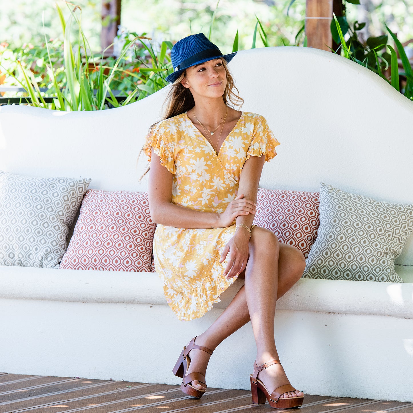 Woman enjoying the sun in the Carkella Del Mar Trilby Fedora Sun Hat, offering breathable and lightweight sun protection for summer activities in coastal areas, Mixed Navy