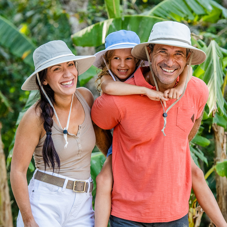 Family outside wearing matching bucket style summer sun hats by Wallaroo