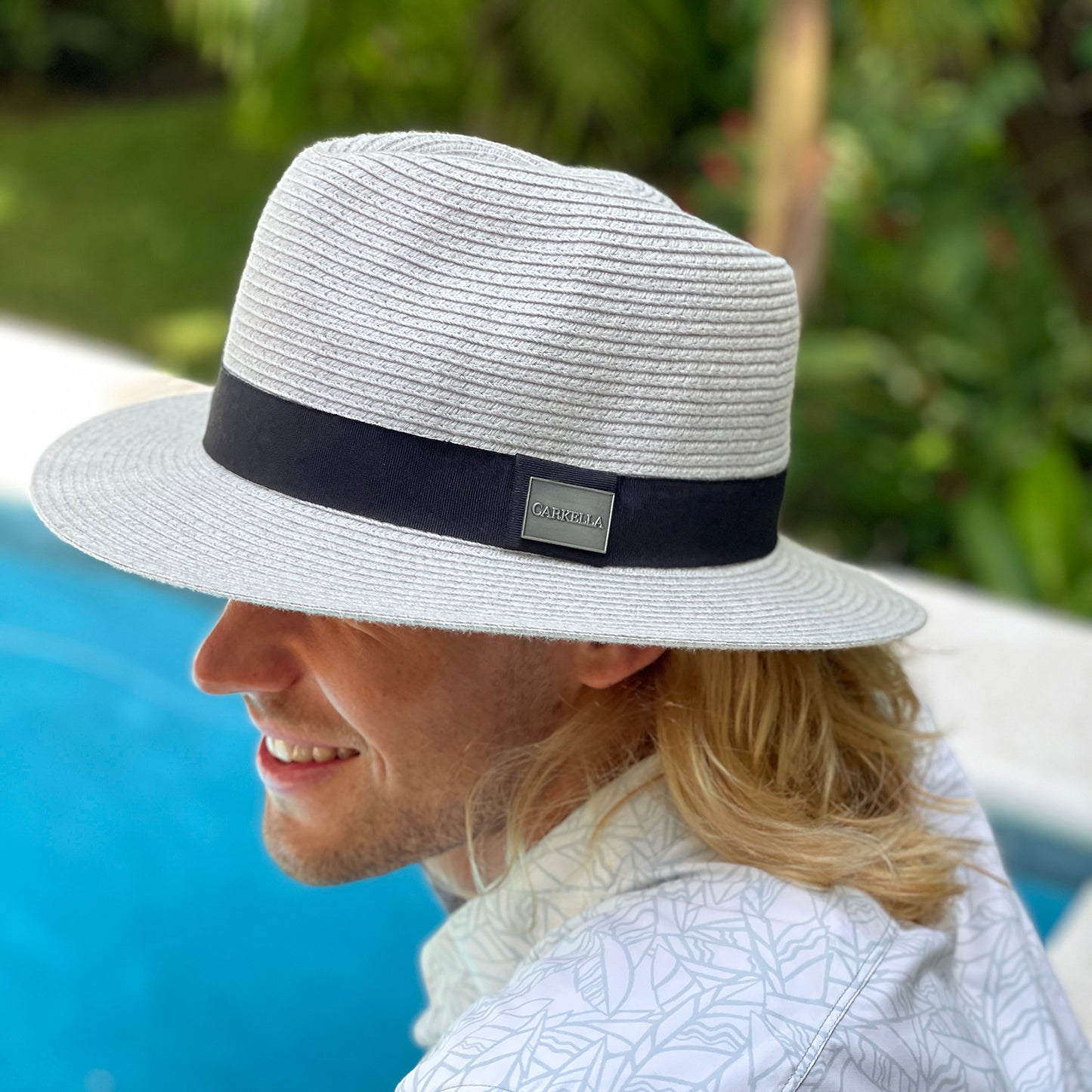 Man enjoying a day at by the resort pool, wearing the Carkella Fairway Fedora Sun Hat for superior sun protection, perfect for long days by the water, Light Grey