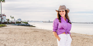 Woman posing in Coronado, California, wearing an extra-large sun hat with a wide brim, offering breathable UPF 50+ sun protection, thoughtfully designed for women with larger head sizes