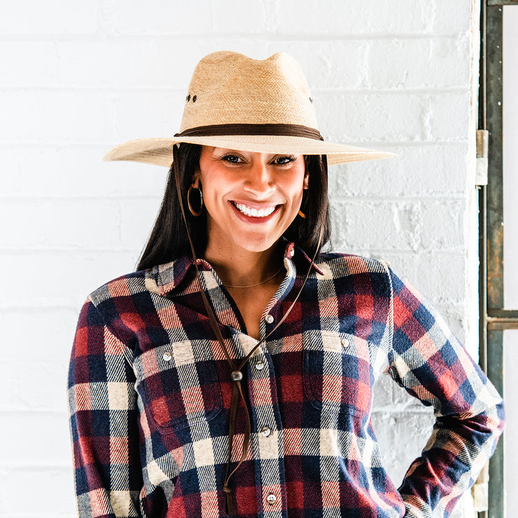 Woman in fall/winter clothing wearing a Big Camel wide brim straw sun hat by Wallaroo