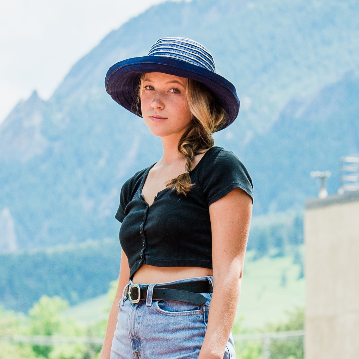 Woman wearing the Breton wide-brimmed hat with mountains in the background