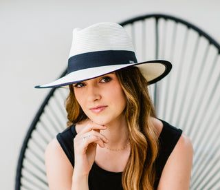 woman sitting while wearing a big wide brim sun hat by Carkella