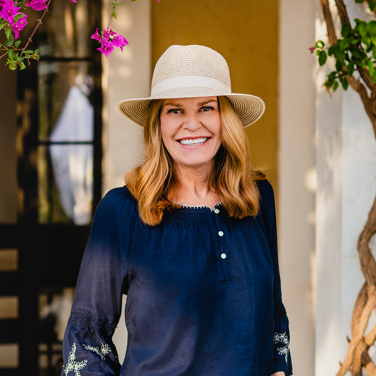 Woman standing on a city street in the Wallaroo Caroline Fedora, stylish and functional sun protection for urban explorers, Beige