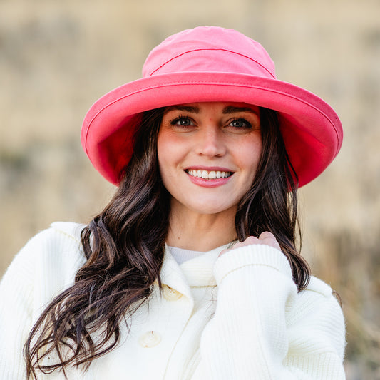 Woman wearing a big wide brim UPF sun hat outside, Coral