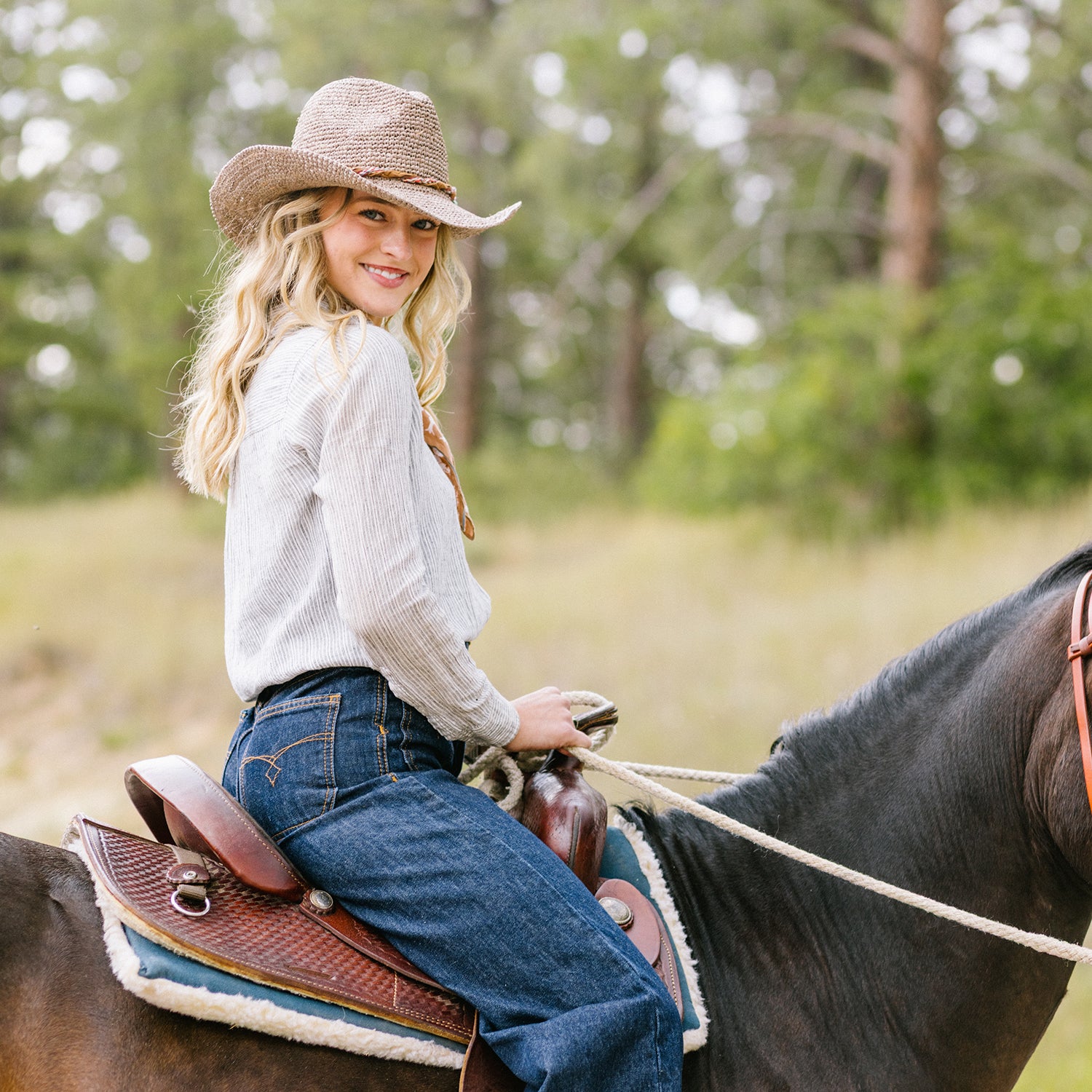 Woman riding a horse in a natural setting with trees in the background wearing Catalina Cowboy sun hat, Mushroom