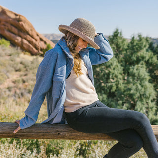 Woman wearing the Wallaroo Catalina Raffia Sun Hat while exploring Red Rocks at Morrison, Co, providing sun protection and stylish comfort for outdoor activities, Mushroom