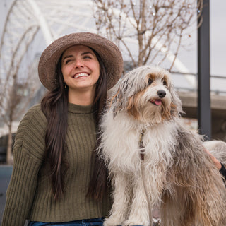 Woman outside with a dog wearing a straw sun hat, Mushroom