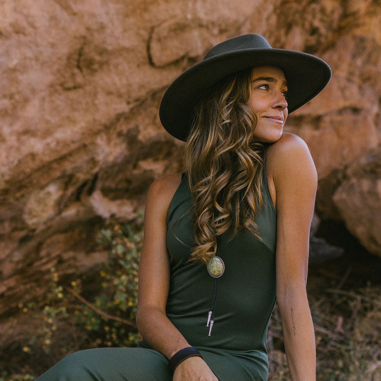 Woman enjoying a mountain outing at Red Rocks in the Wallaroo Women’s Colorado Felt Sun Hat, combining UV protection and a cozy, elegant design for winter getaways, Truffle