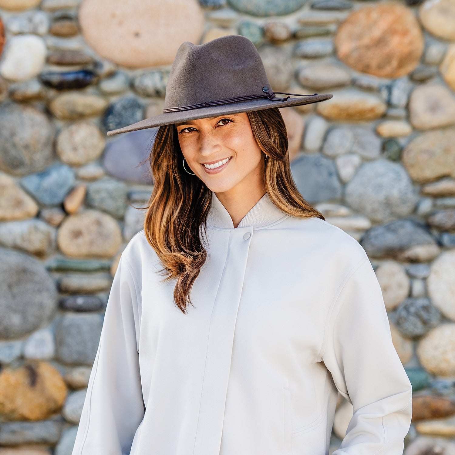 Woman posing in the Wallaroo Colorado Felt Fedora Sun Hat, showcasing its timeless wide brim design and reliable UPF 50+ sun protection, Truffle