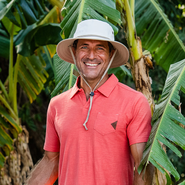 Man gardening in the backyard with the Wallaroo Explorer Wide Brim Hat, combining style and practical UV protection for long hours in the sun, Natural/Camel