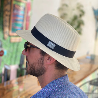 A patron at a restaurant wearing the Carkella Fairway Fedora Sun Hat on a summer day, providing stylish sun protection while enjoying outdoor activities, Ivory