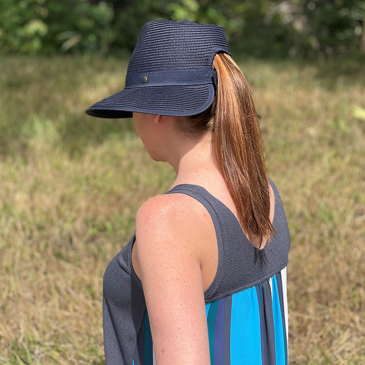 woman walking outside while wearing the Wallaroo Gabi ponytail sun hat