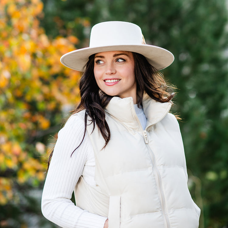 Woman strolling through a sunny city park in the Wallaroo Indo Fedora Hat, showcasing its wide brim, stiff structure, and chic design for active urban lifestyles, Pearl