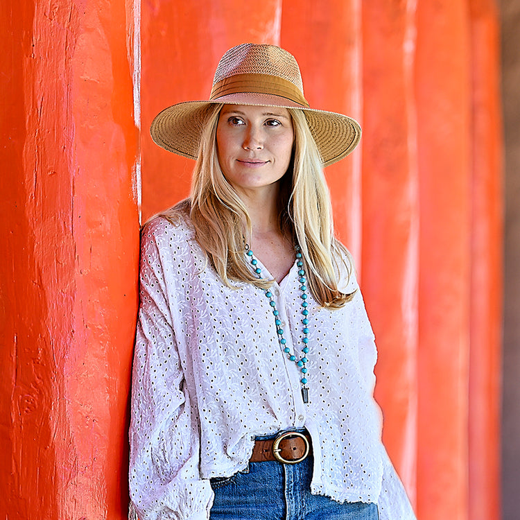 woman posing while wearing a wide brim sun hat by Wallaroo