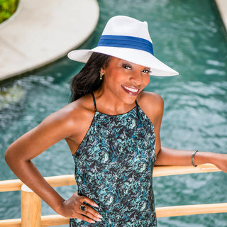 Woman wearing a big wide brim fedora style straw summer sun hat by Wallaroo, White