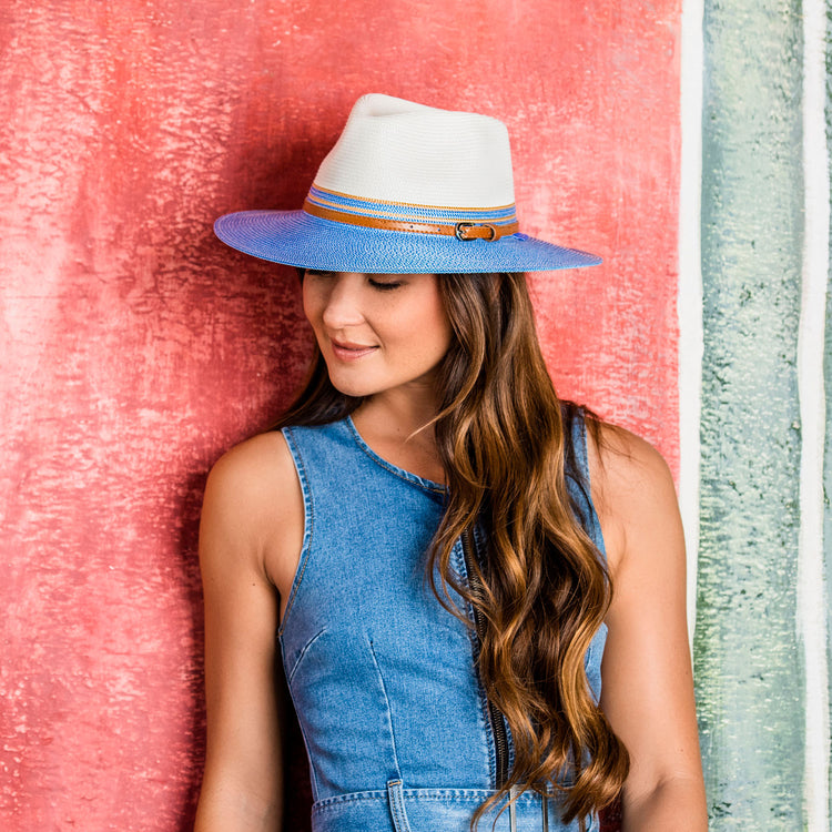 Woman at art museum courtyard, shaded by the Wallaroo Women's Kristy Sun Hat, combining wide brim style with UPF 50+ sun protection, Ivory/Ice Blue