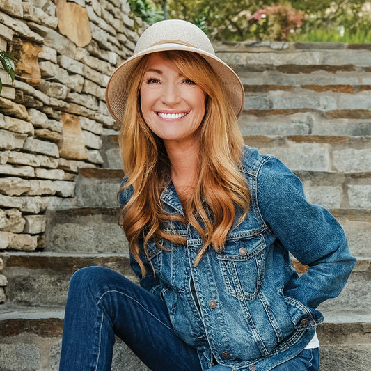 Actress Jane Seymour wearing the women's Lady Brett cloche bucket travel sun hat sitting on stairs, Mixed Camel