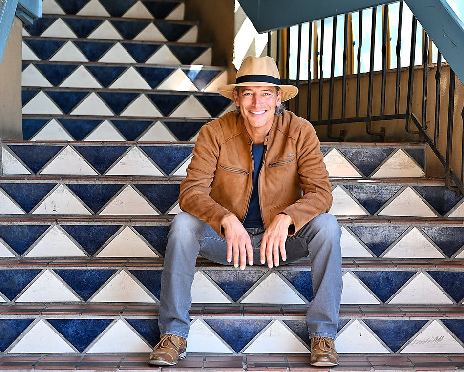 Man sitting on steps wearing a fedora sun hat by Wallaroo