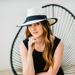 Woman enjoying an outdoor garden party, wearing the Carkella Lauren Women's Fedora, combining elegance with sun protection for a sophisticated day in the sun, Ivory