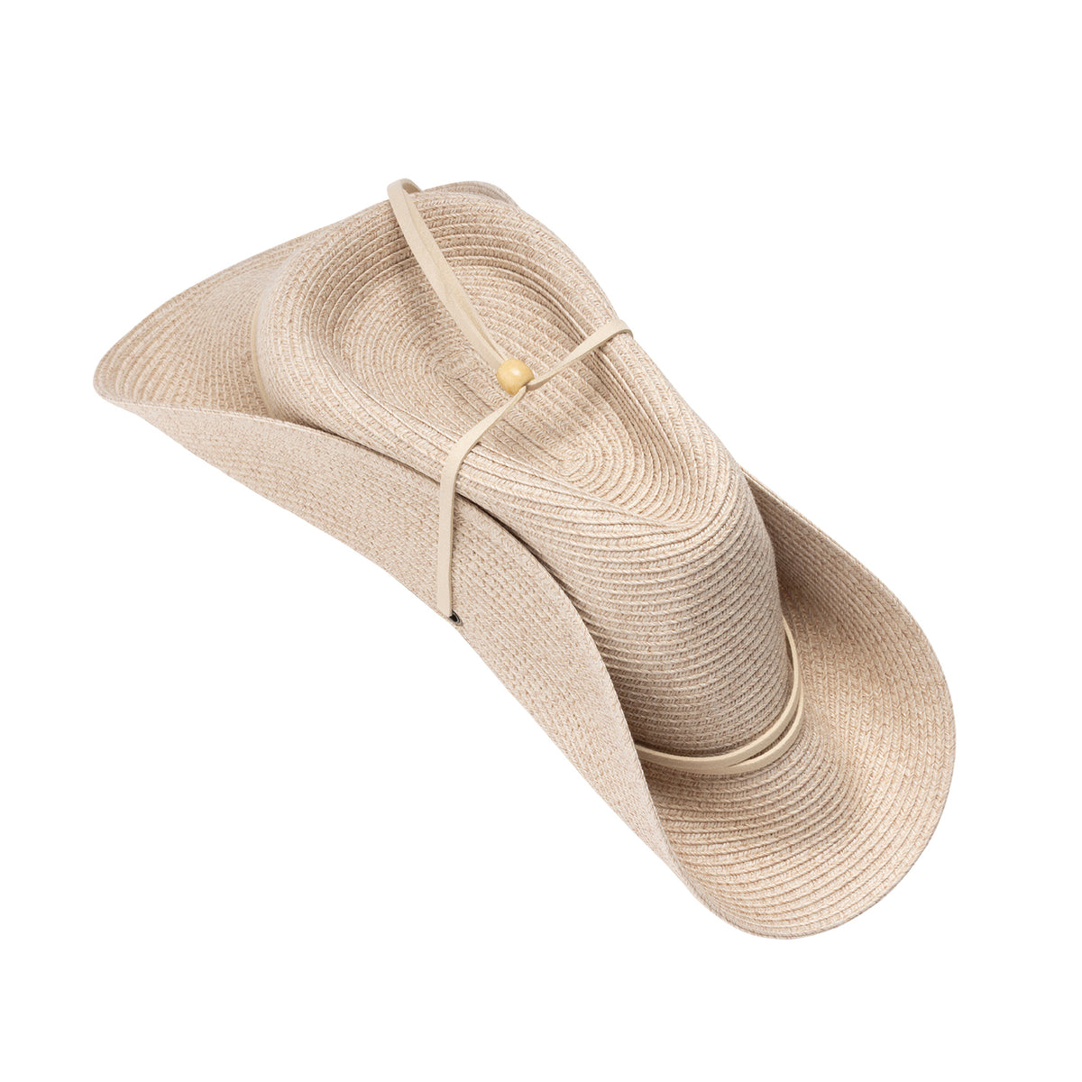 An angled view of the Lexi UPF 50+ fedora hat in mixed ivory, folded using the soft taco fold packing method, secured with a thin strap decorated with a wooden bead, shown against a plain white background.