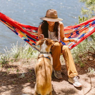 Woman enjoying the lake, protected from the sun in the Wallaroo Logan Wide Brim Fedora, combining elegance and practicality for beach events, Camel