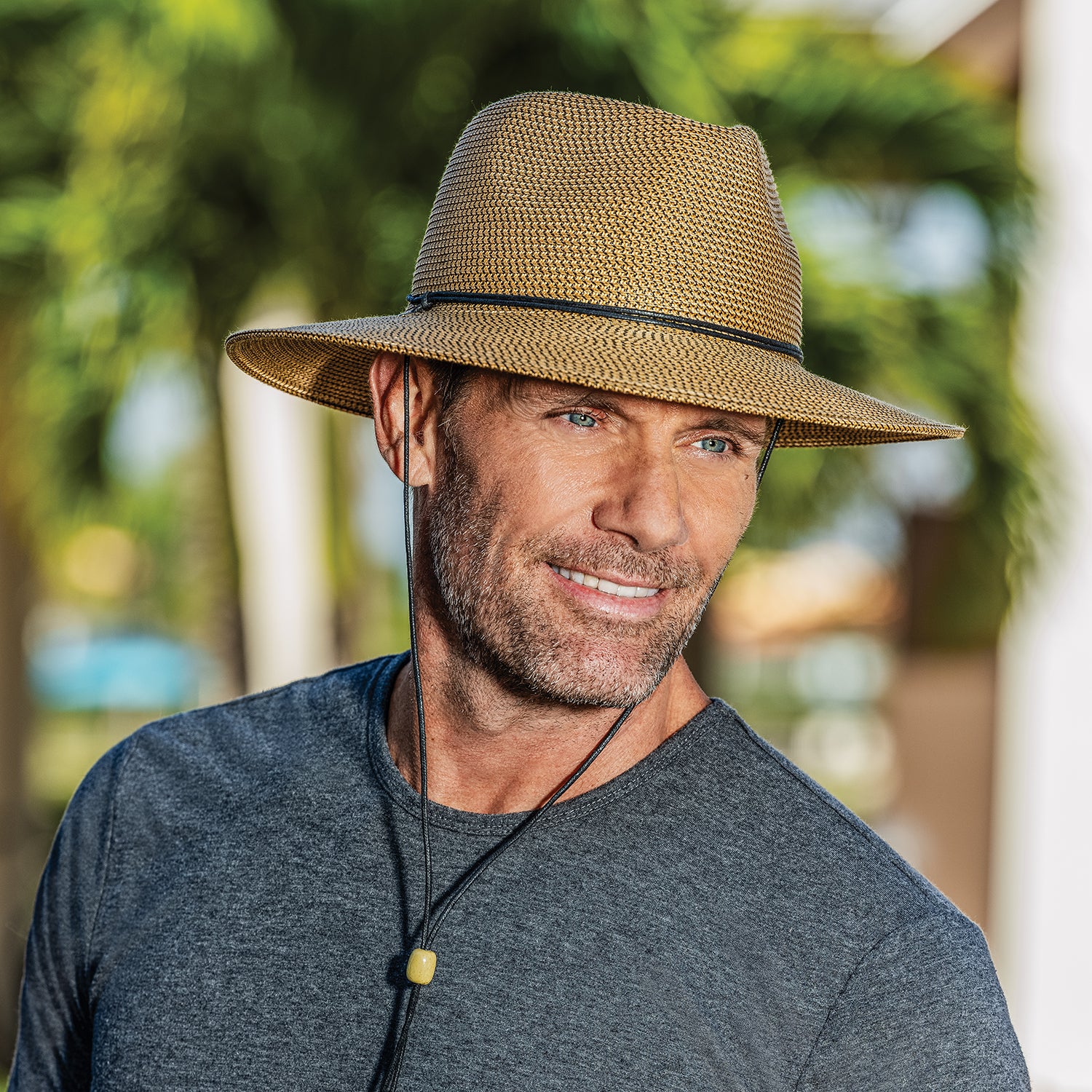 Man protected from the elements in the Wallaroo Logan Fedora Sun Hat, ideal for festivals with a classic design, Camel