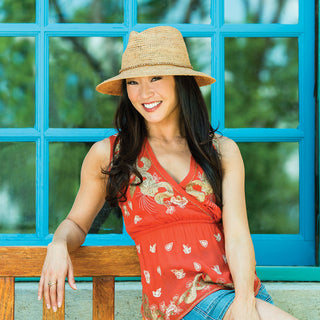 Woman outdoors, wearing the Wallaroo Malibu wide brim UPF 50+ sun hat, perfect for casual strolls in sunny urban environments, Natural