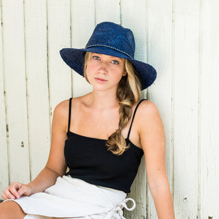 Woman wearing the Wallaroo Malibu sun hat for a chic look and UPF 50+ sun protection under the city’s sunshine, Navy