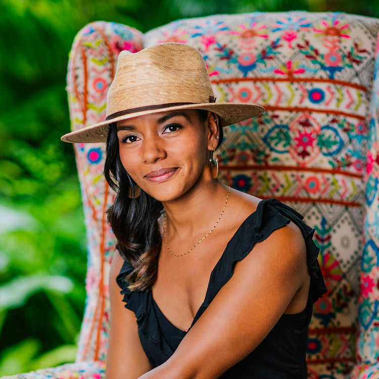 Woman shaded by the Wallaroo Marina medium brim sun hat, crafted with natural fibers through sustainable practices for urban recreation, Camel