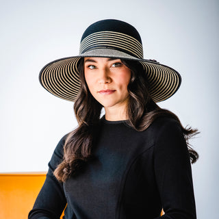 Woman in fall/winter clothing wearing a big wide brim sun hat by Wallaroo, Black/Natural