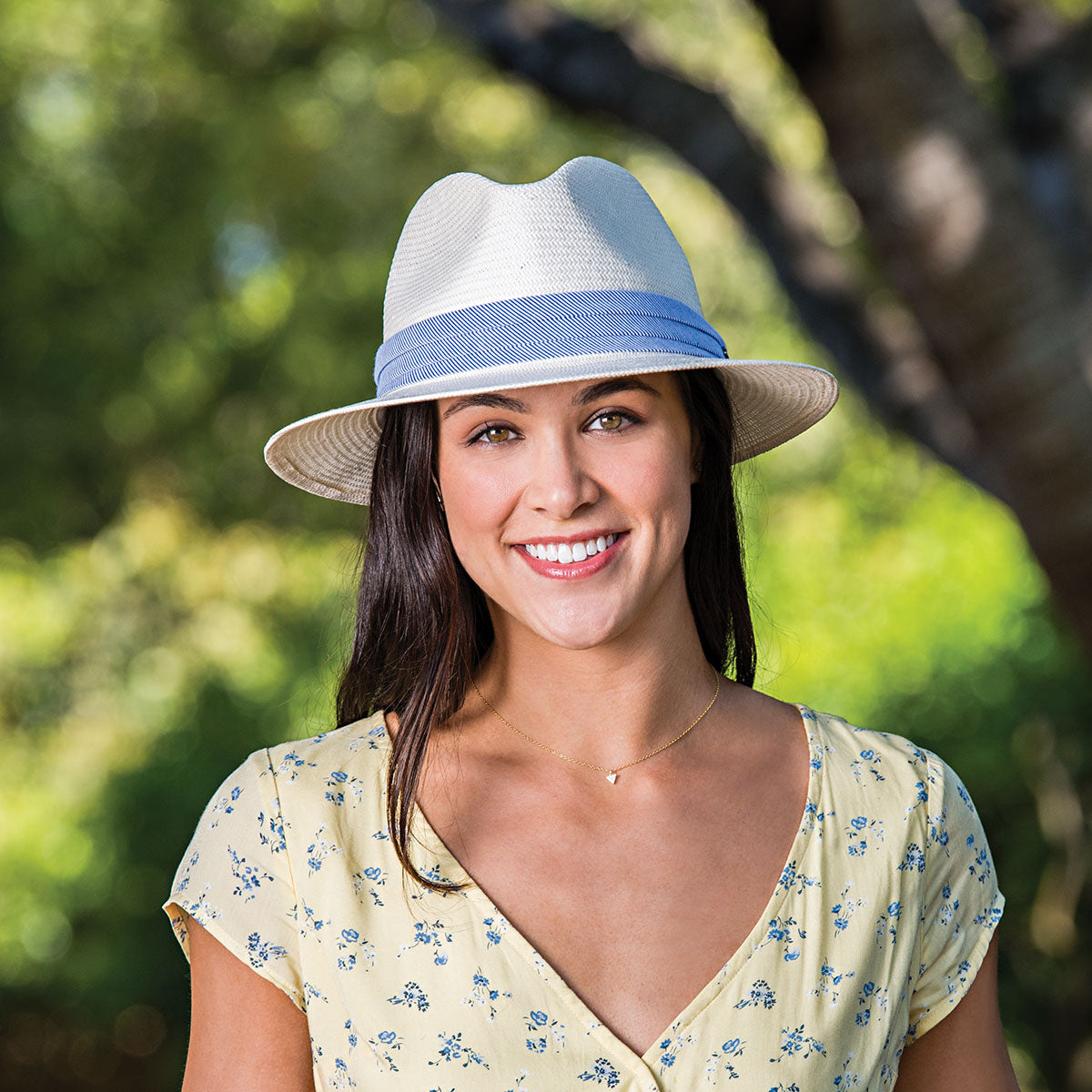 Woman wearing a Monterery straw Sun Hat with a fedora crown by Wallaroo, Natural w/Blue Pinstripe