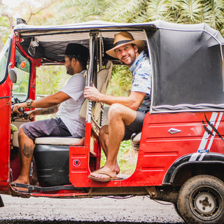 Man in a tuk tuk on a sunny day, wearing the Carkella Palm Beach Panama Fedora Sun Hat, wide brim, designed to provide optimal breathability and UPF 50+ sun protection, Caramel