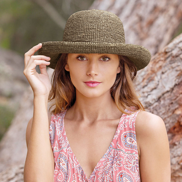 Woman wearing the Wallaroo Petite Catalina Wide Brim Sun Hat while enjoying an afternoon in a botanical garden, perfect for small heads, Mushroom