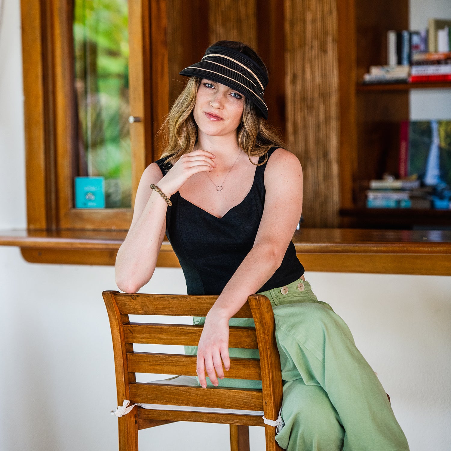 Petite woman wearing the Wallaroo Petite Savannah Wide Brim Visor, combining elegance and sun protection for summer adventures, Black/Camel