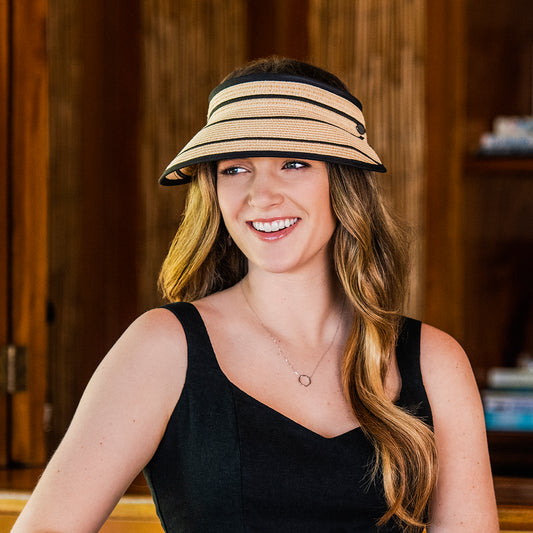 Petite woman protected from the sun with the Wallaroo Petite Savannah Wide Brim Visor, perfect for summer sports and resort activities, Camel/Black