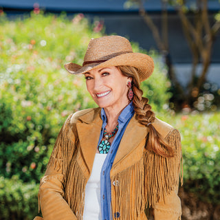 Jane Seymour posing on a rustic wooden deck in the Wallaroo Quinn Sun Hat, showcasing its western-inspired design and UPF 50+ summer sun protection, Camel