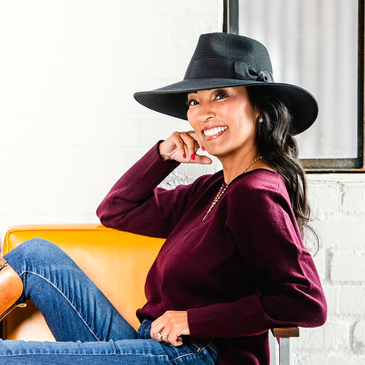 Resort guest lounging in the Wallaroo St Lucia Fedora Sun Hat, featuring a wide brim, perfect for windy summer days, 'Black w/Black Ribbon'