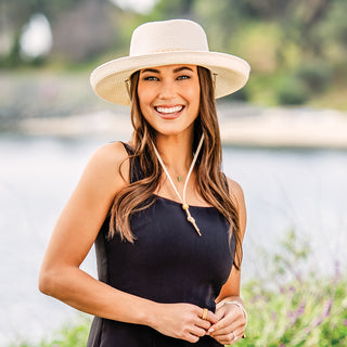 Woman enjoying a Coronado California, shaded by the Wallaroo Stevie Wide Brim Fedora Hat with an upturned brim and chin strap, suitable for sunny and breezy weather, Ivory