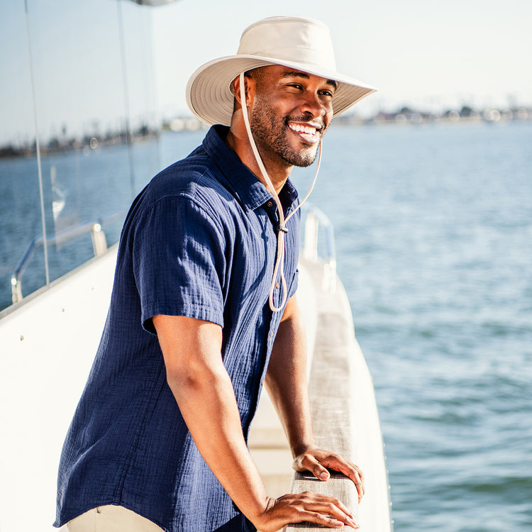 Man outside wearing a wide brim bucket style sun hat by Wallaroo