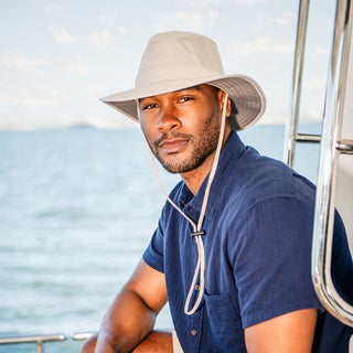 Man outside wearing a wide brim bucket style sun hat by Wallaroo, Stone