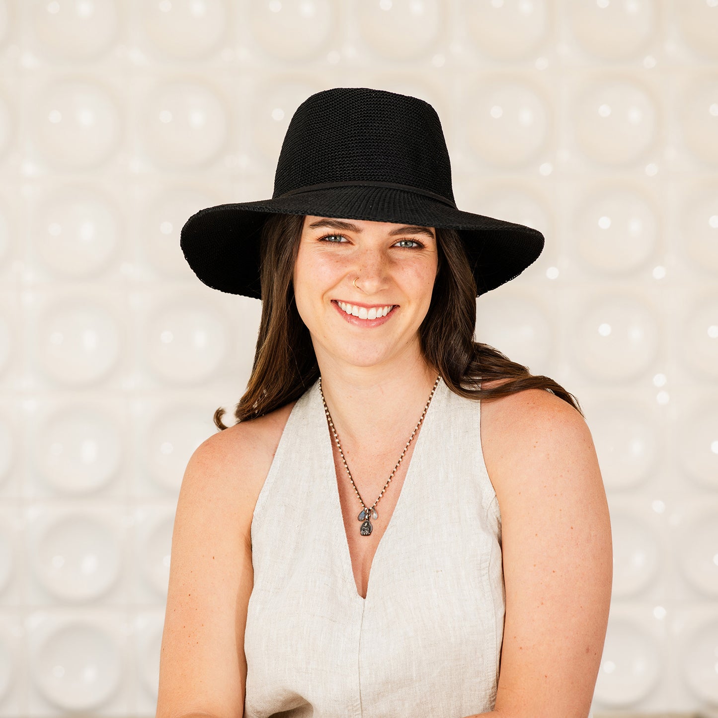 Woman wearing a Victoria Fedora sun protection hat against a textured background, Black