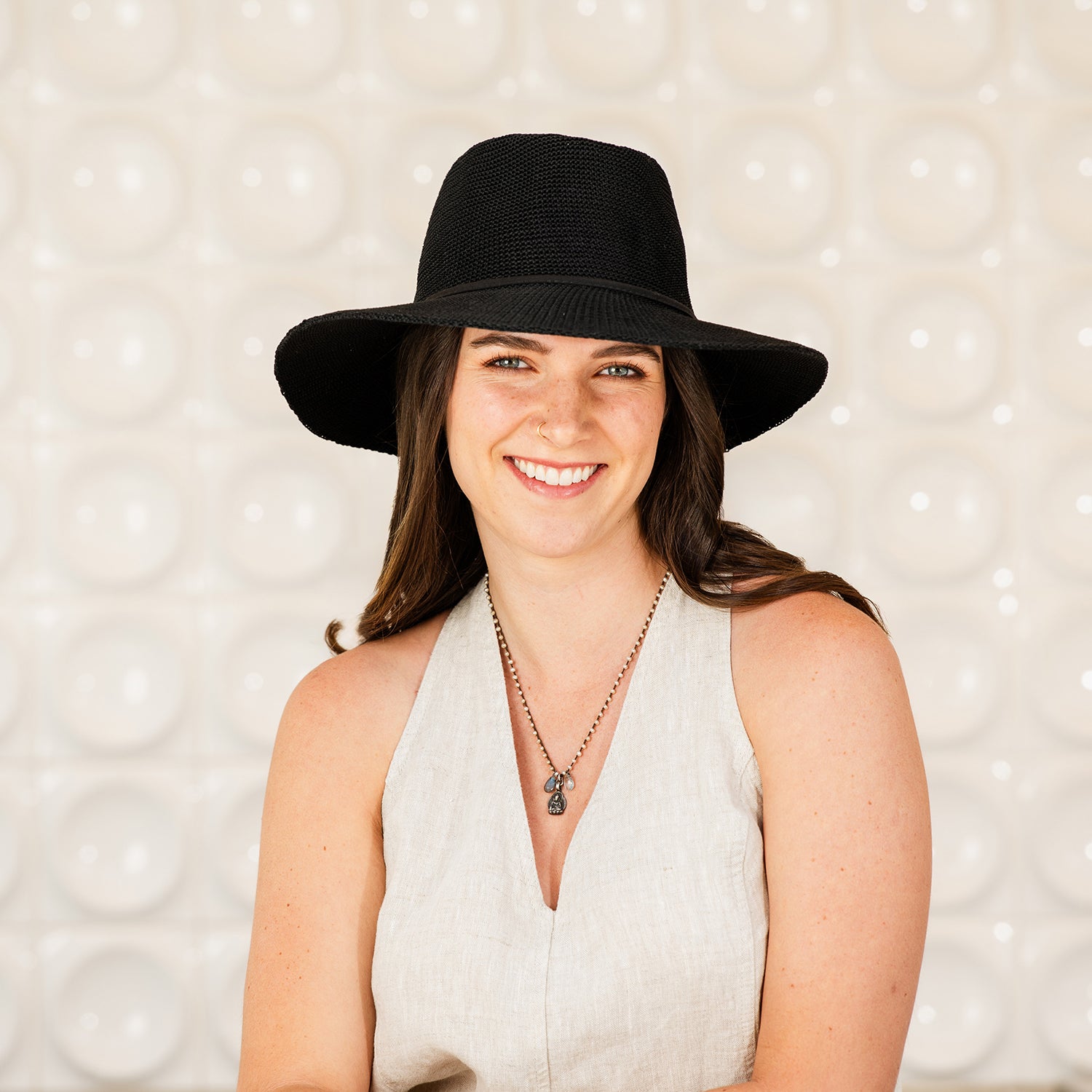 Woman wearing a Victoria Fedora sun protection hat against a textured background, Black