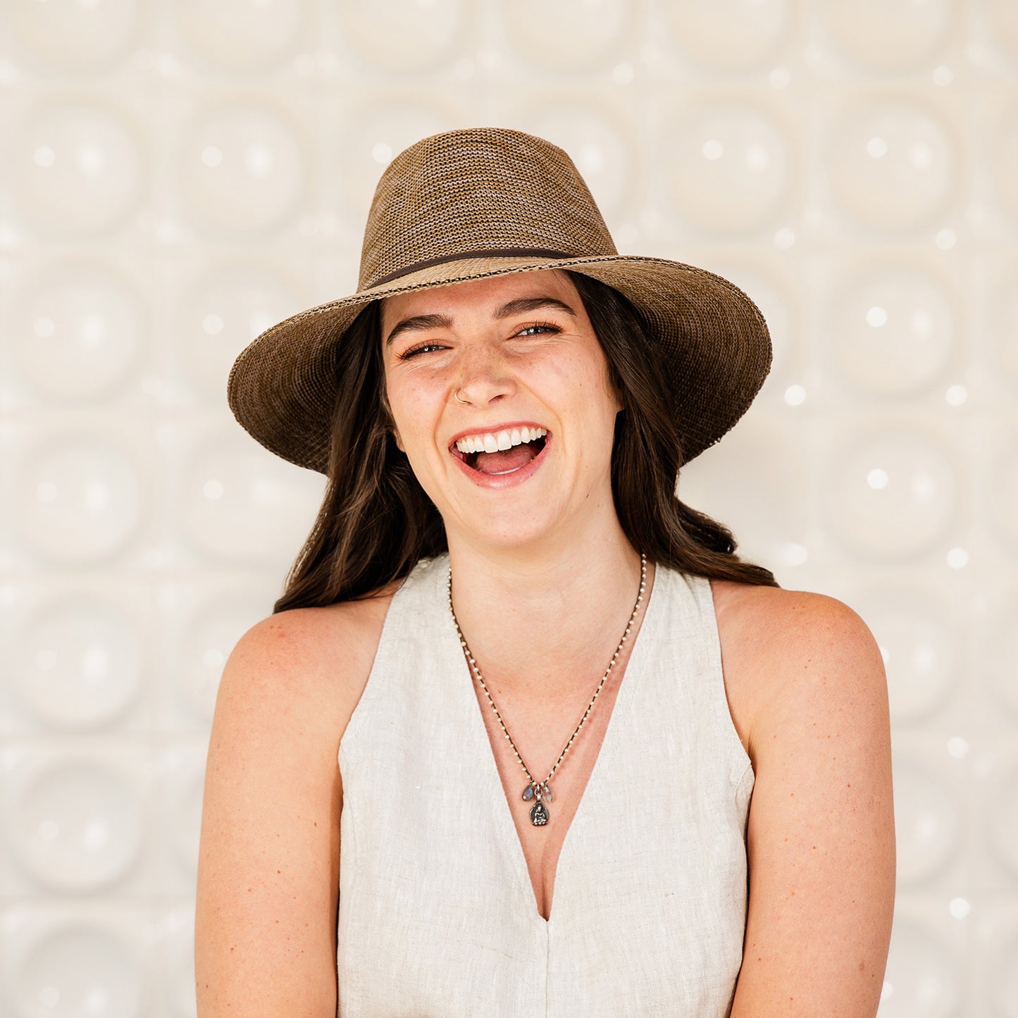 Woman wearing a Victoria Fedora sun hat against a textured background, Suede