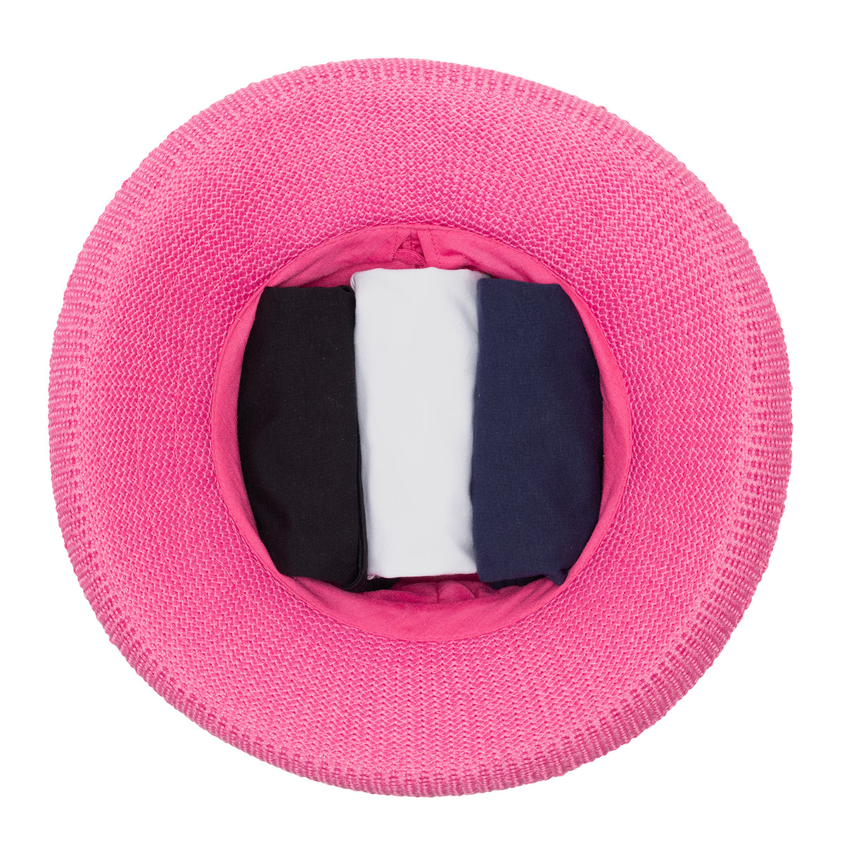 Top-down view of the Wallaroo Victoria UPF sun hat in hot pink demonstrating the "stuff it" packing method, with folded garments packed inside the open crown against a white background.