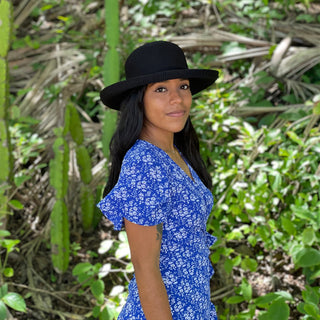 Woman walking along a scenic tropical trail, shaded by the Wallaroo Victoria Sun Hat, offering breathable sun protection for outdoor adventures, Black