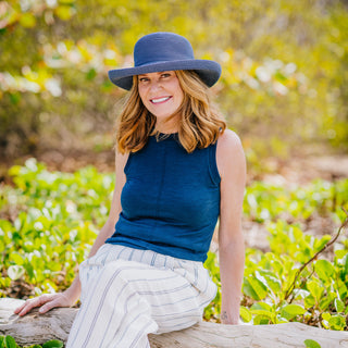 Woman taking in the view, wearing the Wallaroo Victoria Sun Hat, a best-selling poly-straw hat perfect for sunny escapes, 'Dusty Blue'