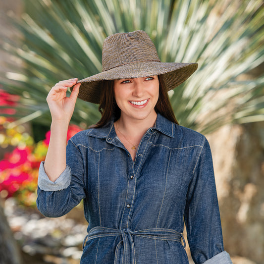 Woman wearing Victoria Fedora Diva sun hat in front of palm tree, Suede